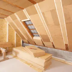 Isolation de combles en cours, avec des panneaux de fibre de bois prêts à être posés.