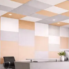 Panneaux acoustiques colorés, blancs, gris et beige, formant un motif à damier sur le mur et le plafond, parfaits pour isoler phoniquement un mur.
