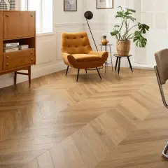 Un salon moderne avec un **pose parquet point de hongrie** en bois clair, un fauteuil moutarde et un buffet vintage.
