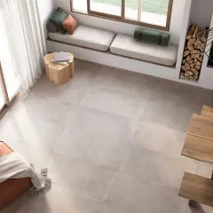 Un salon lumineux avec un **schema plancher bois** discret, un banc près de la fenêtre, un pouf et une table en bois.