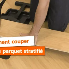 Main tenant une lame pour la découpe du parquet stratifié. Outil de coupe pour parquet.