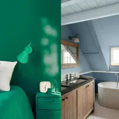 Chambre verte avec un lit et une lampe, et salle de bain bleue avec baignoire et lavabo. Les murs sont recouverts d'une peinture mat ou satin.