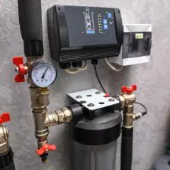 Détail du plan d'installation surpresseur : manomètre, filtre, boîtier de commande et réservoir rouge.