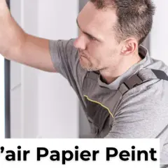Un homme en tenue de travail lisse un mur pour enlever une bulle d'air dans du papier peint sec.