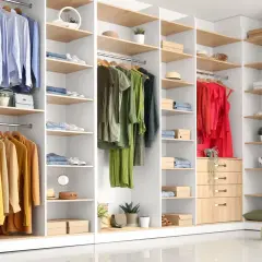 Un dressing bien organisé avec des vêtements suspendus et pliés, des chaussures et des accessoires. Un plan dressing dimensionné pour optimiser l'espace.