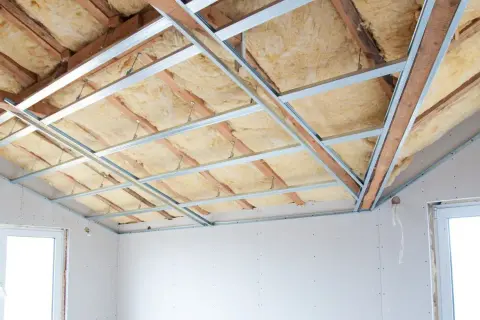 Isolation du plafond d'un appartement en cours de rénovation, avec laine minérale et ossature métallique.