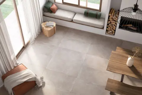 Un salon lumineux avec un **schema plancher bois** discret, un banc près de la fenêtre, un pouf et une table en bois.