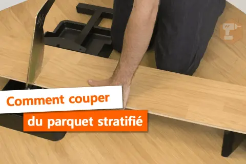 Main tenant une lame pour la découpe du parquet stratifié. Outil de coupe pour parquet.