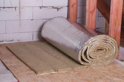 Rouleau d'isolant thermique à faible épaisseur, prêt à être posé sur un plancher en bois. Idéal pour une isolation performante et discrète.