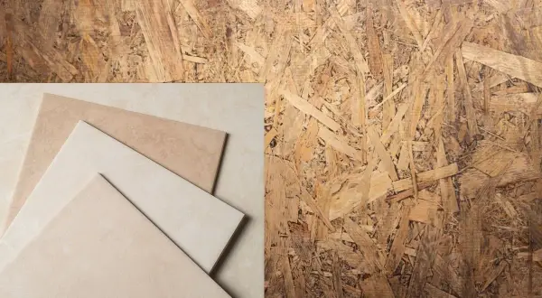 Un panneau de pose OSB avec des carreaux de céramique beiges et marron disposés en diagonale.
