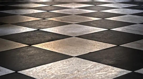 Un sol en damier noir et blanc, posé en diagonale, crée une perspective saisissante. L'avantage de cette pose de carrelage diagonale est son effet d'agrandissement visuel.