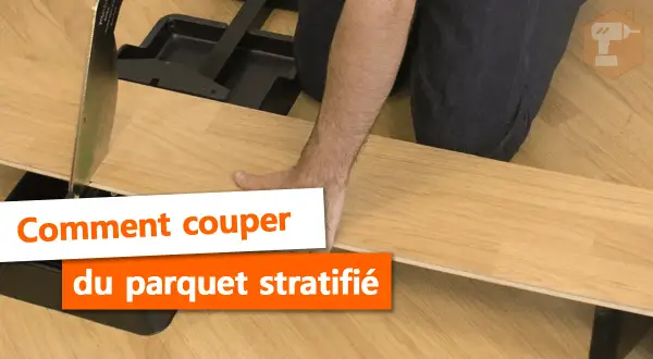 Main tenant une lame pour la découpe du parquet stratifié. Outil de coupe pour parquet.