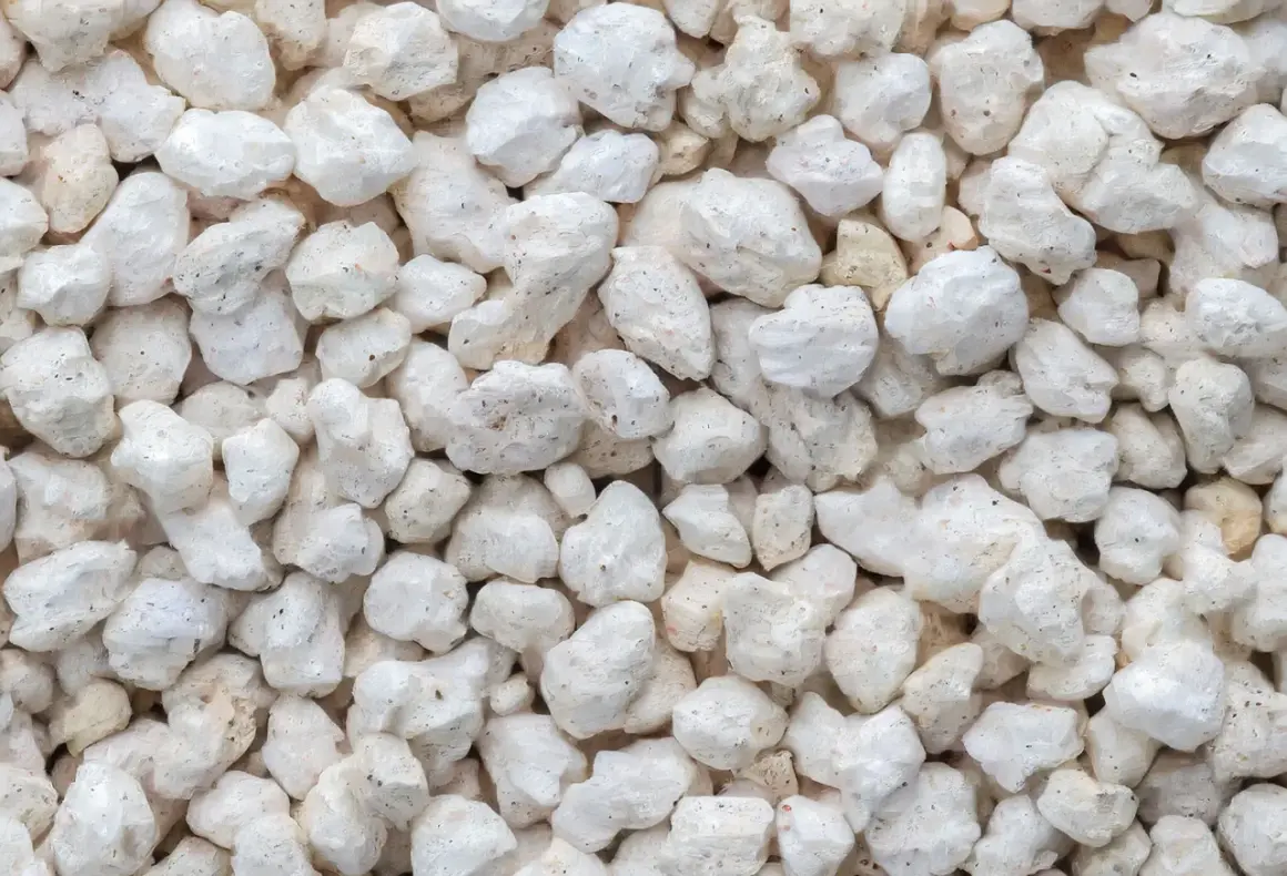 Gros plan sur des granulés blancs et irréguliers, typiques de la perlite utilisée pour l'isolation.