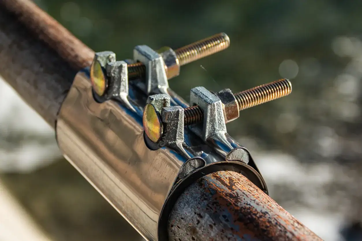 Collier de r&eacute;paration sur un tuyau en cuivre rouill&eacute;, destin&eacute; &agrave; colmater une fuite.