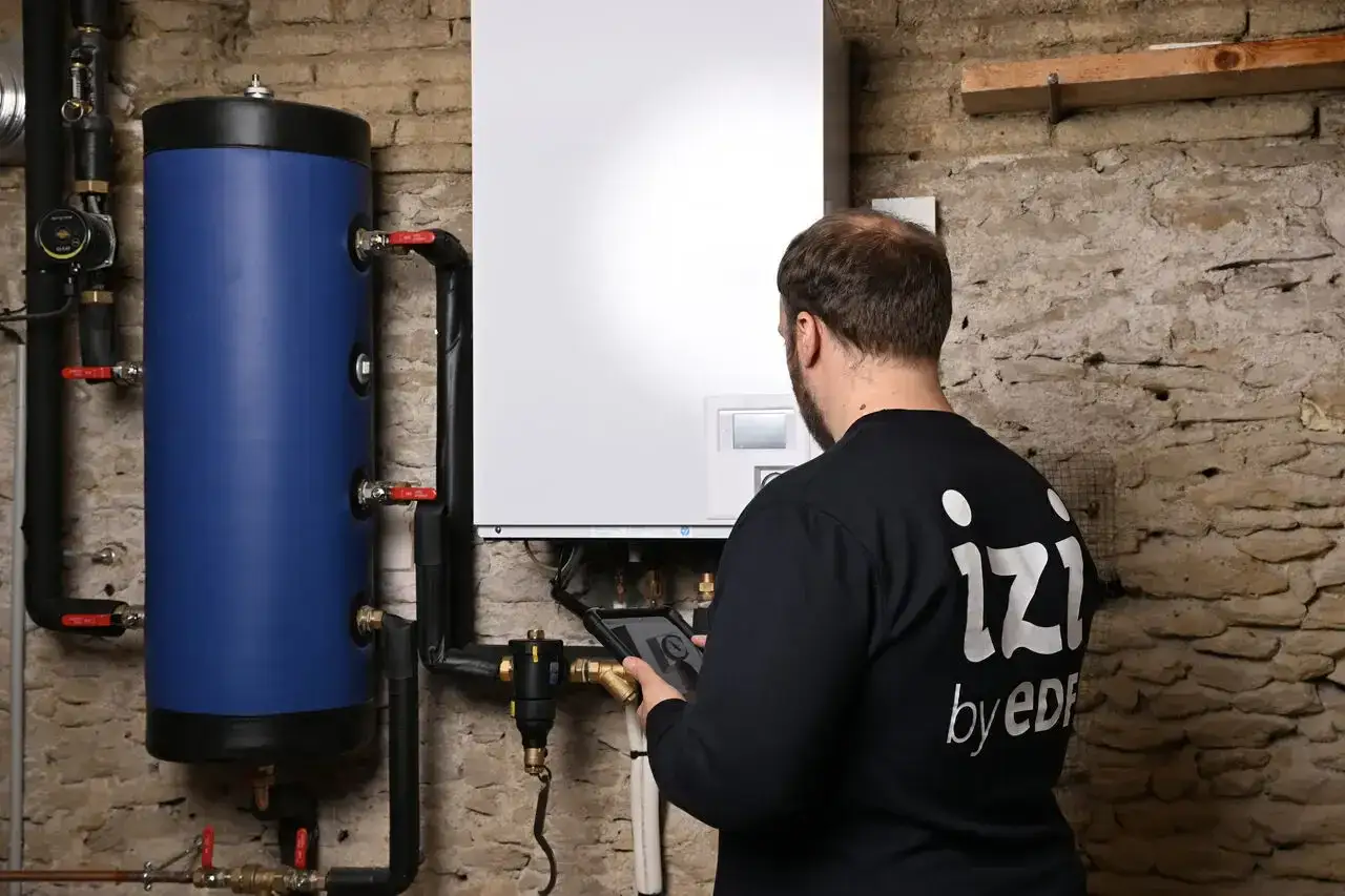 Un technicien v&eacute;rifie le bon fonctionnement d'un chauffe-eau thermodynamique, optimisant sa dur&eacute;e de vie.