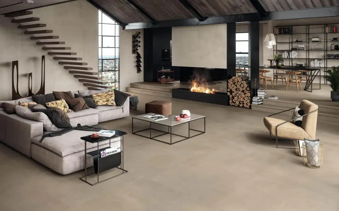 Salon moderne avec cheminée, escalier flottant et canapé confortable, le tout sur un sol en pose carrelage 60x60.