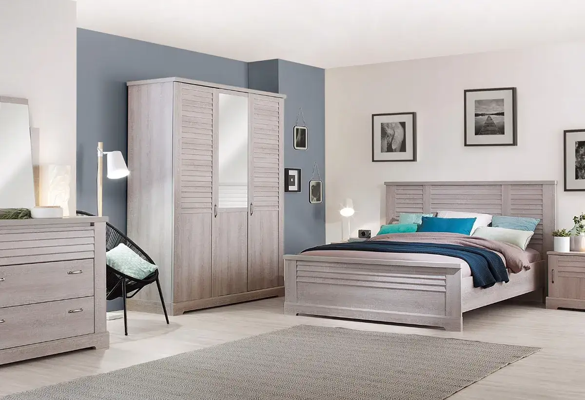 Chambre adulte 2 couleurs : lit, armoire et commode en bois clair, mur bleu.