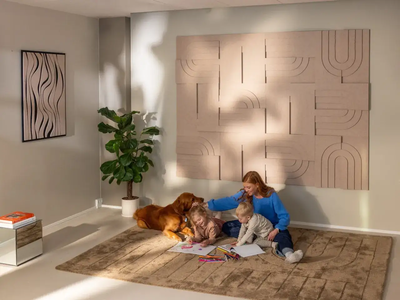 Une famille profite d'un moment calme pour dessiner, un chien &agrave; leurs c&ocirc;t&eacute;s. Le mur est d&eacute;cor&eacute; de panneaux acoustiques, une solution pour comment insonoriser une chambre &agrave; coucher.