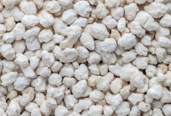 Gros plan sur des granulés blancs et irréguliers, typiques de la perlite utilisée pour l'isolation.