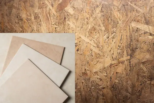 Un panneau de pose OSB avec des carreaux de céramique beiges et marron disposés en diagonale.